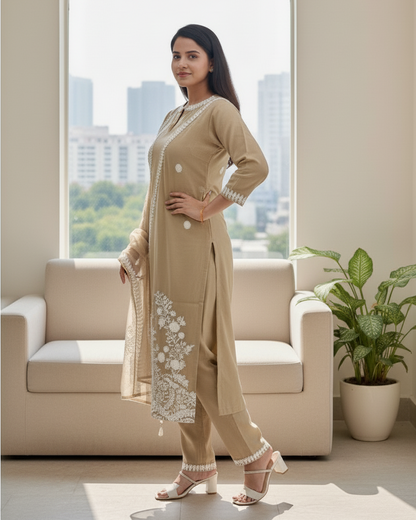 Woman in a beige traditional outfit standing in a modern living room with a cityscape view.